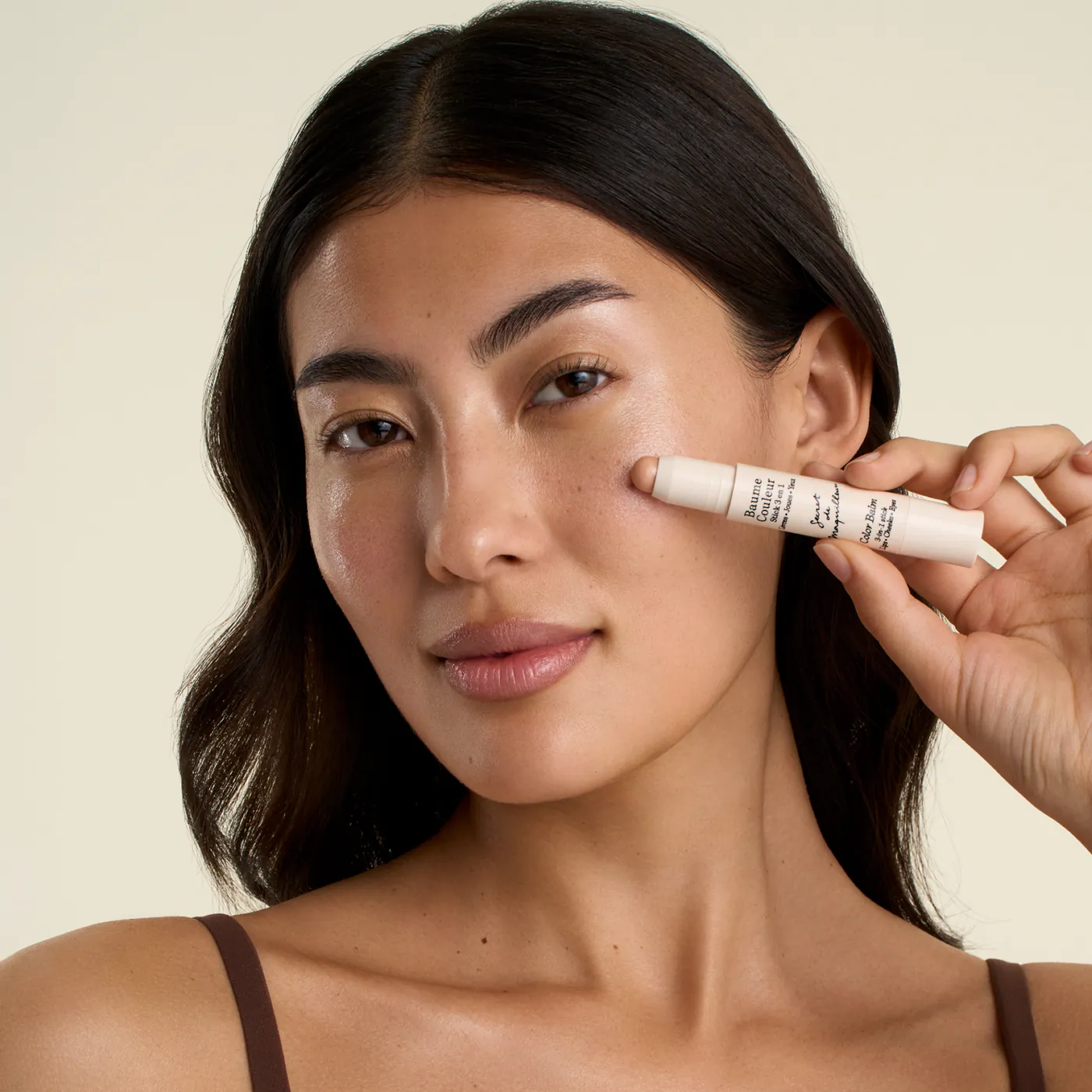 Yanağına Baume Couleur stick süren bir kadın